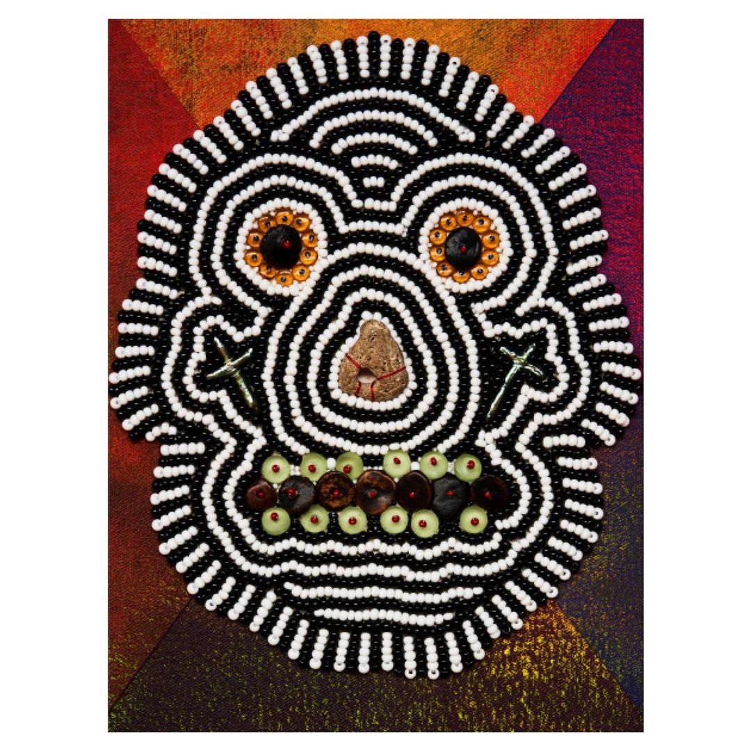 Artistic skull decoration with beads, stones, and cross shapes on colorful textured background. Halloween and Day of the Dead themed image.