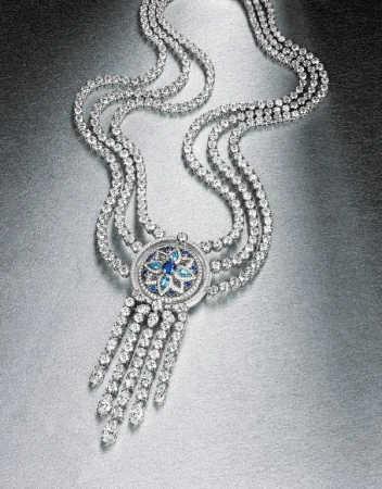 Elegant diamond necklace featuring cascading strands and a blue gemstone floral design on a metallic silver backdrop, jewelry photography.