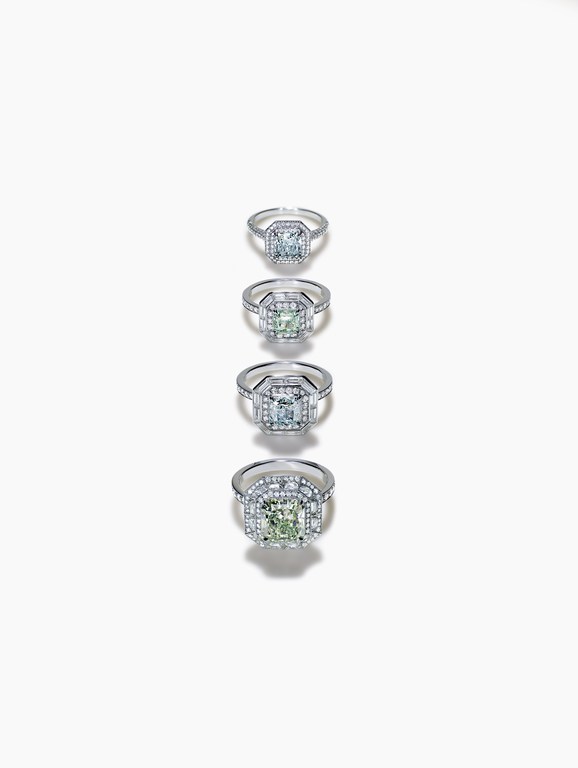 Four engagement rings featuring square-cut stones, set in silver with pave detailing, are aligned on a bright white surface.