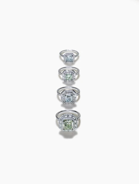 Four engagement rings featuring square-cut stones, set in silver with pave detailing, are aligned on a bright white surface.