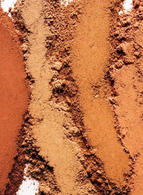 Macro photo of cosmetic bronzer powder swatches in various shades of brown and bronze for beauty and makeup products.