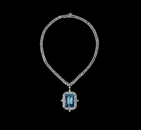 Elegant necklace with a large aquamarine pendant surrounded by diamonds, set against a stark black backdrop to enhance its brilliance.