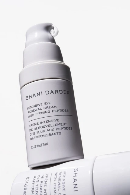Close-up of two white and grey bottles of Shani Darden Intensive Eye Renewal Cream with Firming Peptides. Beauty, skincare, cosmetic.