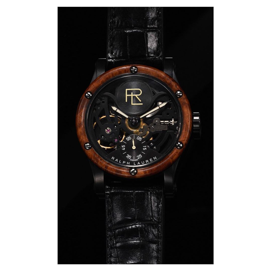 Luxury Ralph Lauren skeleton watch with a wood bezel and a black alligator strap on a dark background, highlighting craftsmanship and design.