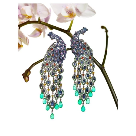 Close-up of ornate peacock earrings with colorful gemstones, set against a delicate white orchid and a stark white background. Jewelry.