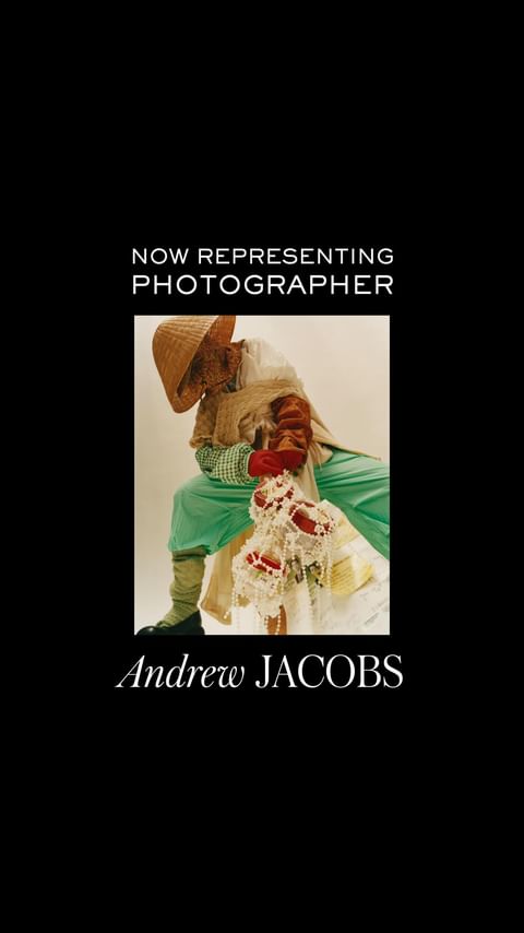 Figure covered in woven straw, wearing a conical hat and green outfit, sits against a light background, advertising photographer Andrew Jacobs.