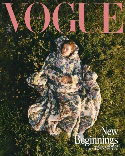 Vogue Poland cover featuring a woman in a floral puffer jacket lying in a grassy field with 'New Beginnings' text; overhead shot.