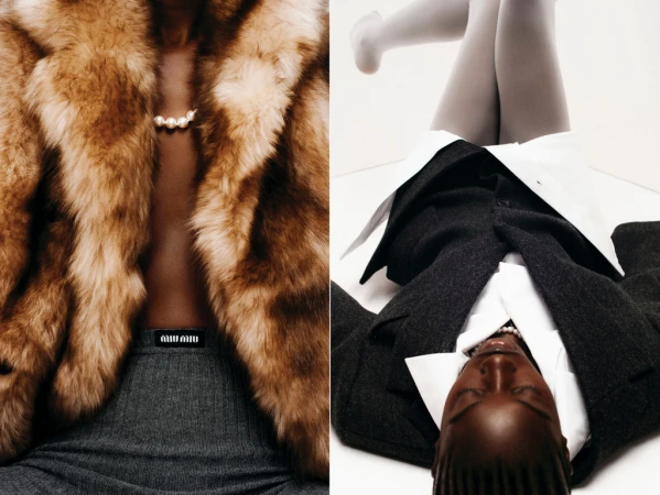 Fashion shot showcases a woman in a fur coat and a second woman in a suit lying on her back, shot in a bright studio.