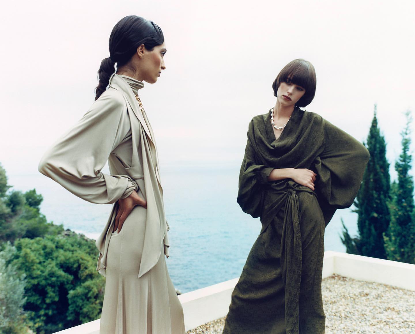 Two female models posing on a terrace overlooking the sea, photographed by Markn.