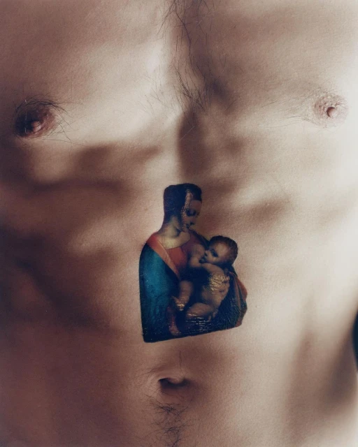 Close-up of bare male chest with a tattoo of Madonna and Child in the center. Body hair is visible. Skin tone is fair.