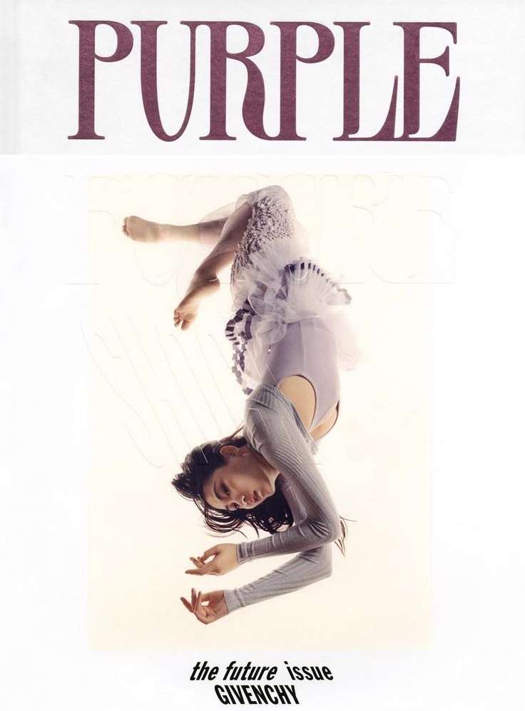 Magazine cover featuring a woman in a light purple dress and grey sweater, upside down against a white background, with bold 'PURPLE' text.