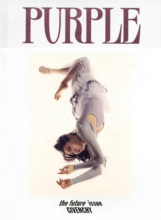 Woman in grey top and white tulle skirt suspended upside down against a white background with purple text at the top