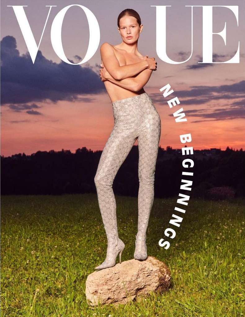 Vogue cover featuring a woman standing on a rock in a field at sunset, wearing patterned leggings and holding her arms across her chest.