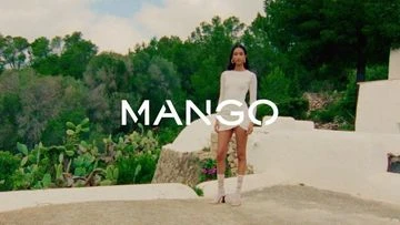 A woman in a white dress stands on a patio against a lush green landscape, promoting Mango fashion with a bright, sunny ambiance.