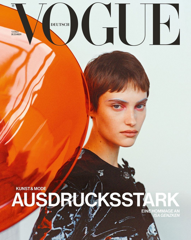 Vogue Deutsch magazine cover featuring a short-haired woman in a dark glossy patterned top beside a large translucent orange sphere.