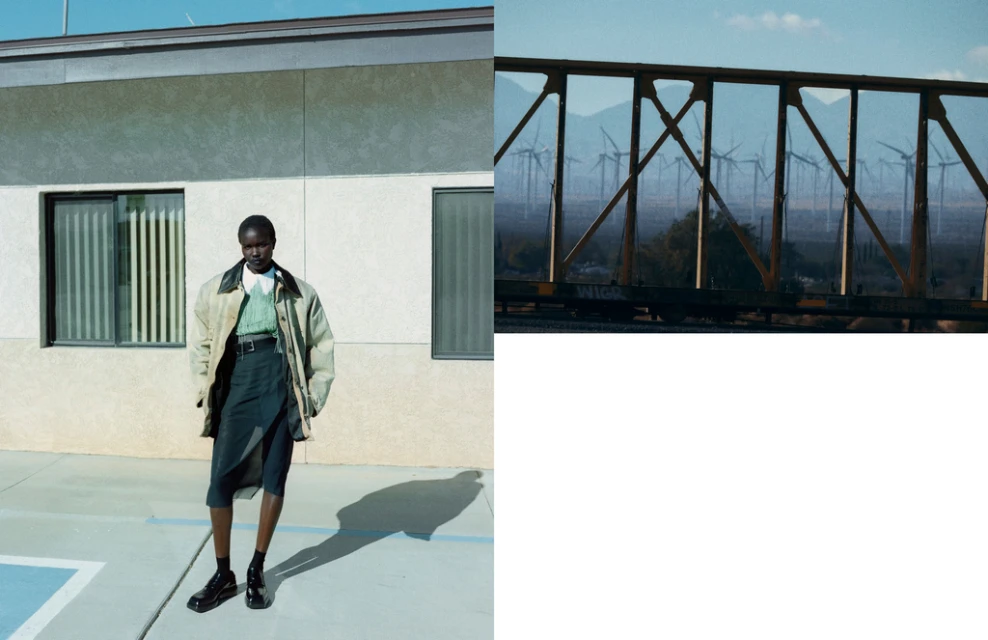 Fashion shot of a woman wearing a jacket and skirt in front of a building, complemented by a blurred background of wind turbines.