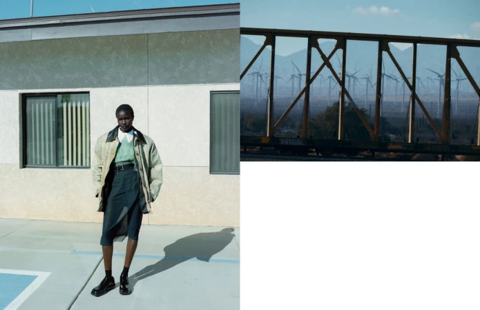 Fashion shot of a woman wearing a jacket and skirt in front of a building, complemented by a blurred background of wind turbines.