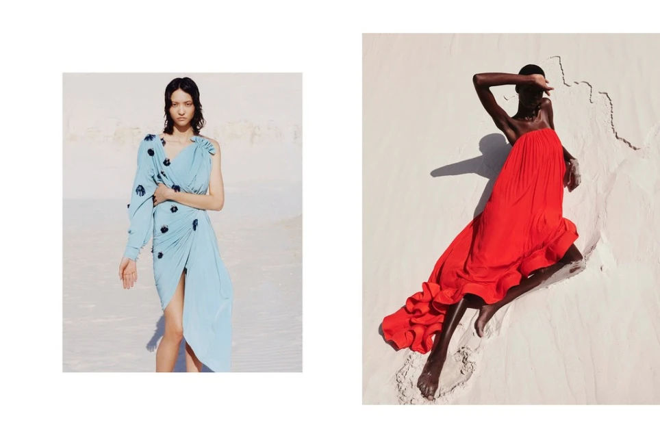 Two fashion models pose in desert settings wearing elegant draped dresses. One is light blue, the other is a long red gown.