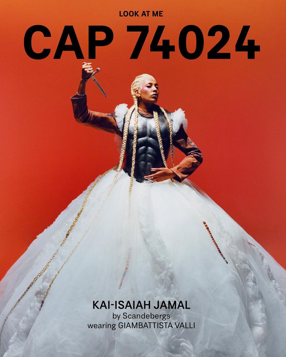 Person in avant-garde fashion gown with a knife, posing against an orange background in a studio. Editorial fashion shot. 