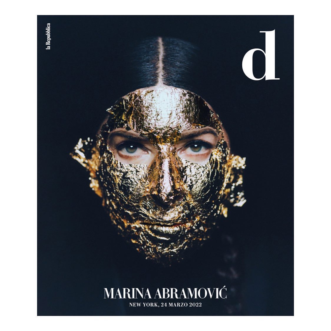 Magazine cover featuring an adult woman with golden foil on her face, a black background, and white text for the publication title.