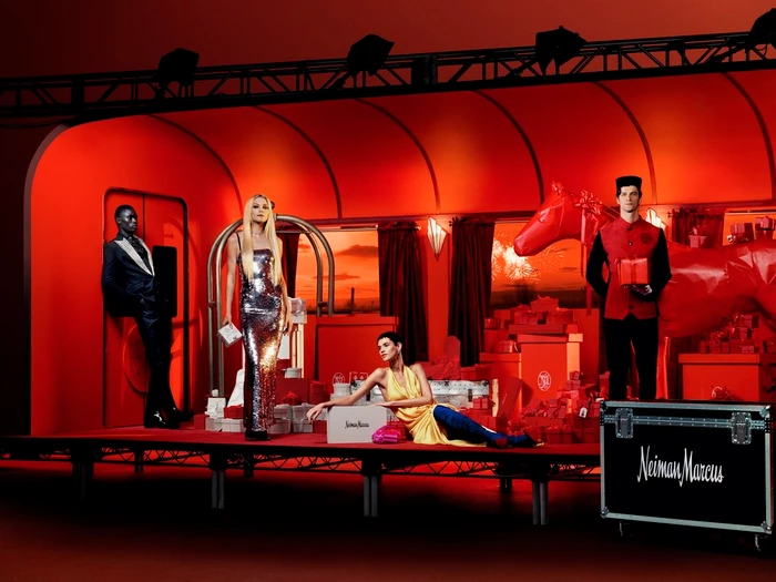 Four models posed in a vivid red set surrounded by wrapped gifts, captured by photography duo Scandebergs.