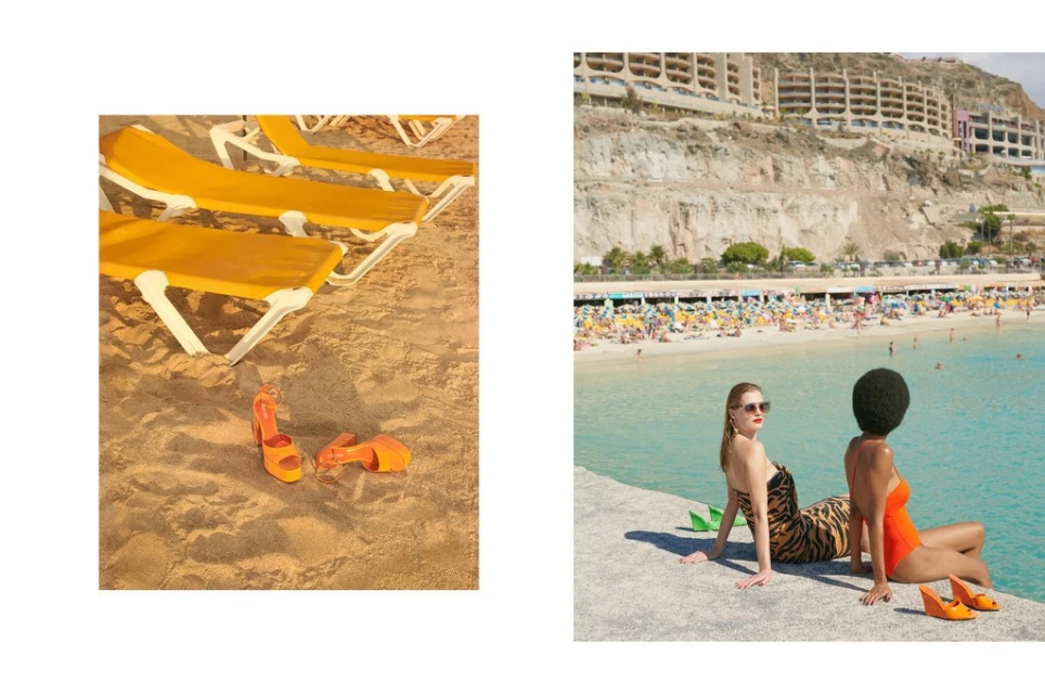 Two women pose near a beach with turquoise water and mountains, complemented by orange high-heeled shoes; a juxtaposed scene with beach chairs.