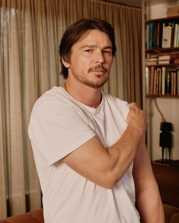 Portrait of Josh Hartnett in a white t-shirt with a mustache inside a domestic room styled by Venetia Scott