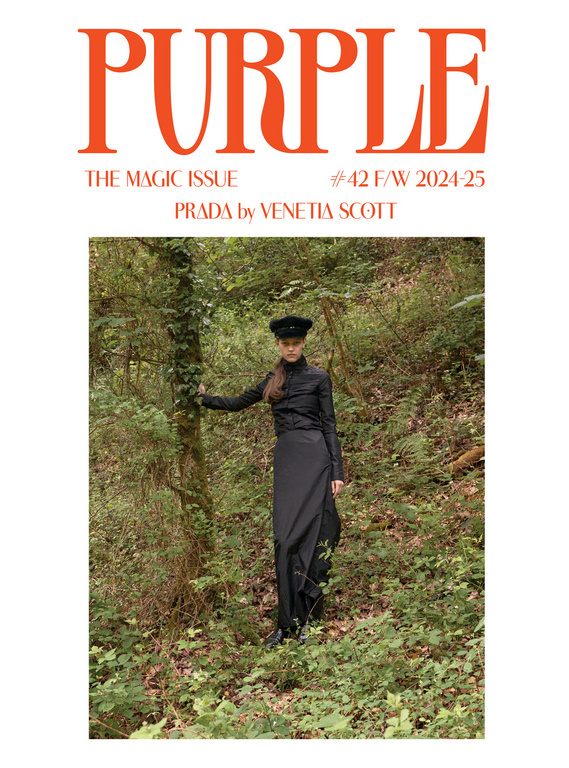 Fashion magazine cover featuring a model in a black dress standing in a forest setting with a bright purple masthead.