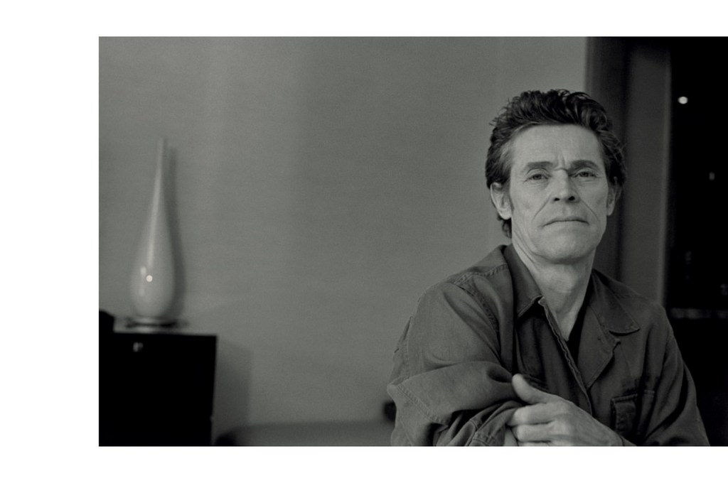 Black and white portrait of actor Willem Dafoe in an interior setting styled by Venetia Scott