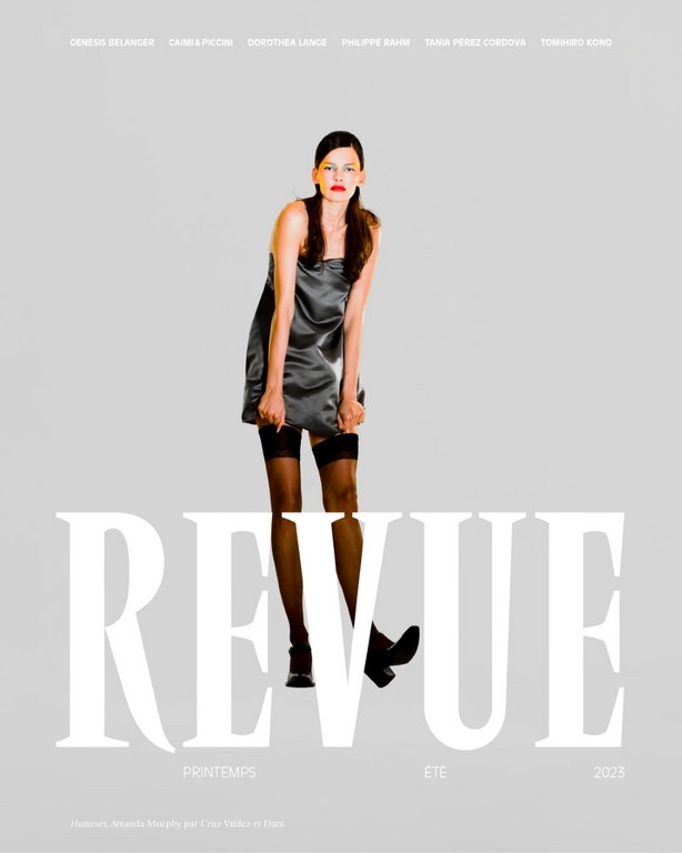 Fashion model poses in short satin dress and stockings for Revue magazine cover, Spring/Summer 2025. Neutral background and studio lighting.