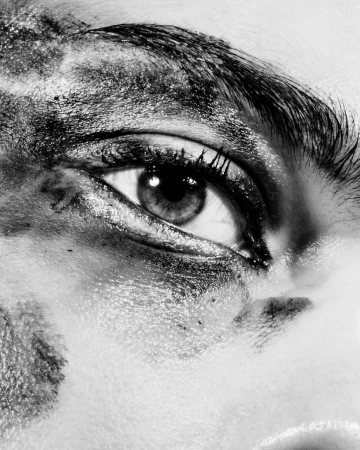 Extreme close up monochrome portrait of an eye with dark smudged makeup and textured skin by Cruz Valdez