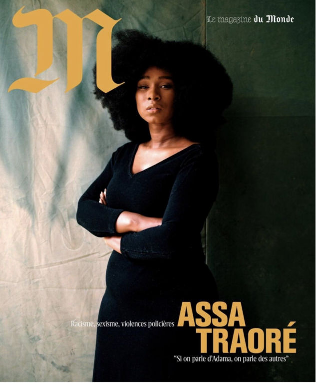 Magazine cover featuring a portrait of a Black woman with large natural hair, wearing a black dress, against a textured background.
