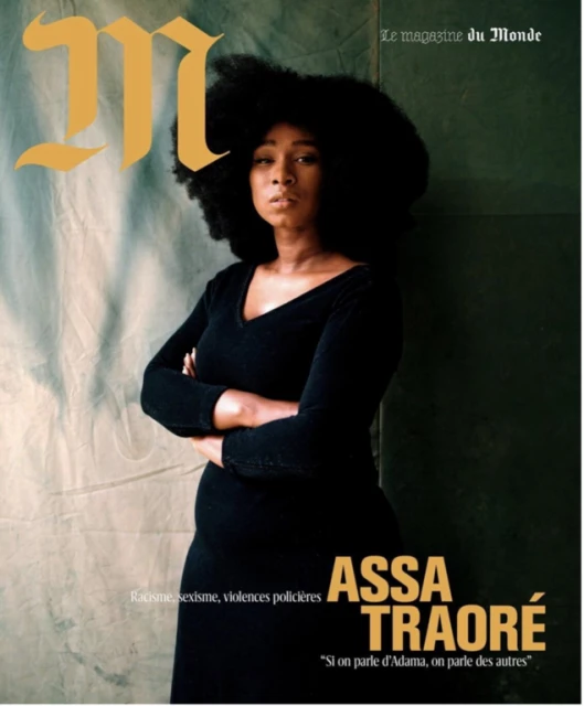 Magazine cover featuring a portrait of a Black woman with large natural hair, wearing a black dress, against a textured background.