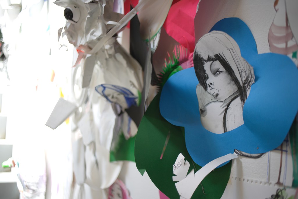 Collage of paper art with drawings of faces and colorful shapes, creating an abstract and whimsical layered visual composition.