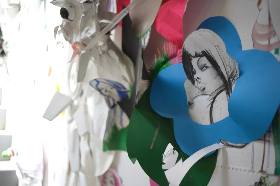 Collage of paper art with drawings of faces and colorful shapes, creating an abstract and whimsical layered visual composition.