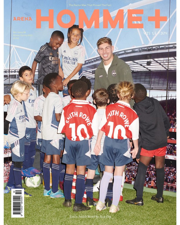 Magazine cover featuring a group of children wearing soccer jerseys and an adult male standing on green grass in front of a stadium.