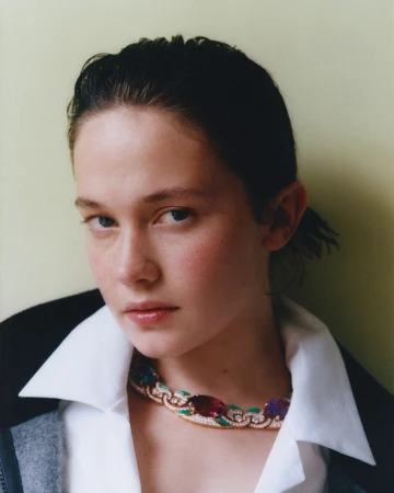 Close-up portrait of a woman wearing a white collared shirt and a statement gemstone necklace styled by Helga Burrill