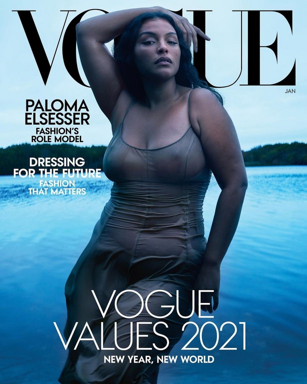 Paloma Elsesser on the cover of Vogue magazine January 2021 issue. The model is standing waist-deep in water. The background shows trees.