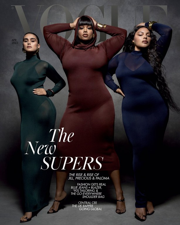 Vogue cover featuring three plus-size models in long-sleeved dresses posing against a gray backdrop, fashion editorial.