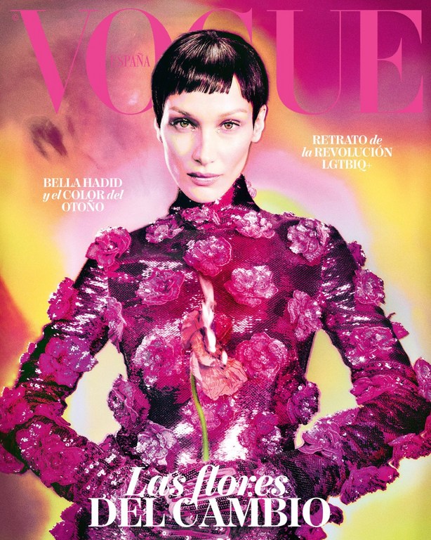 Vogue cover featuring Bella Hadid in a floral-embellished dress, artistic lighting, and bold text overlay against a colorful background.