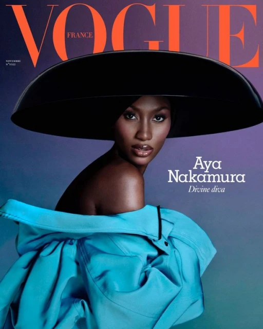 Vogue France cover featuring Aya Nakamura wearing a large black hat and turquoise jacket, against a gradient purple background.