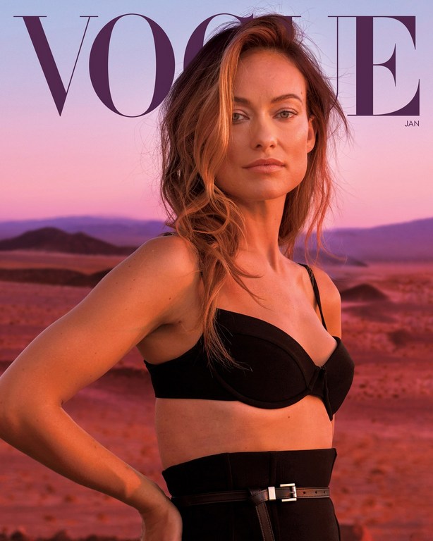 Portrait of Olivia Wilde on a Vogue cover, showcasing black attire and desert background with a pink and purple sky at dusk.