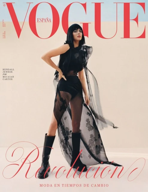 Vogue Espana cover featuring Kendall Jenner in a sheer black dress and boots against a tan and blue backdrop with magazine text.