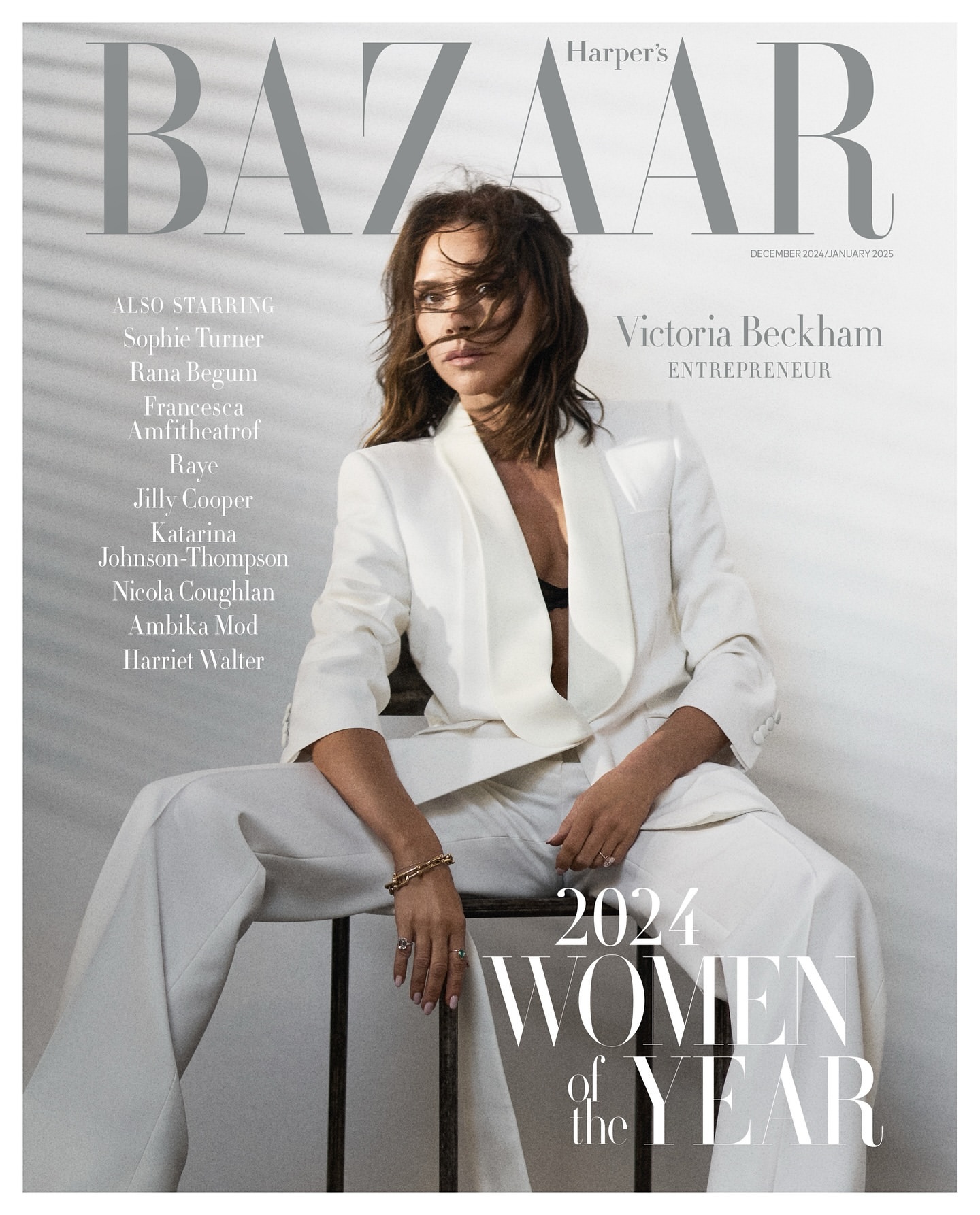 Harper's Bazaar cover featuring Victoria Beckham in a white pantsuit, seated on a metal stool, with magazine text, and light, neutral tones.