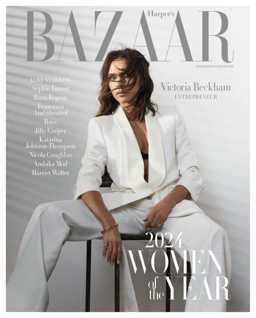 Harper's Bazaar cover featuring Victoria Beckham in a white pantsuit, seated on a metal stool, with magazine text, and light, neutral tones.
