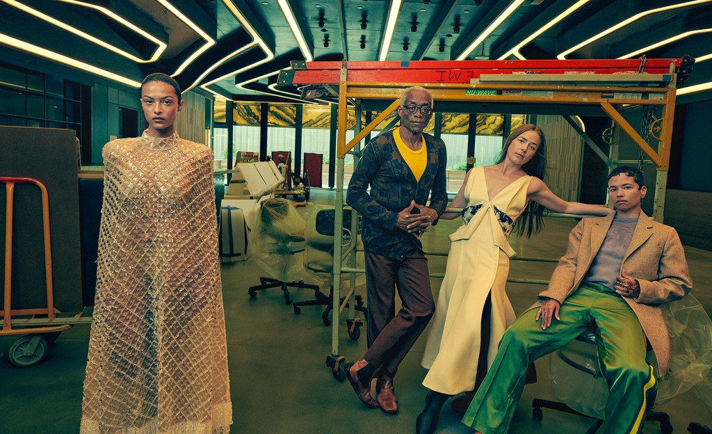 Fashion editorial shot of four diverse adults in a modern interior, featuring unique clothing and accessories, complemented by natural light.