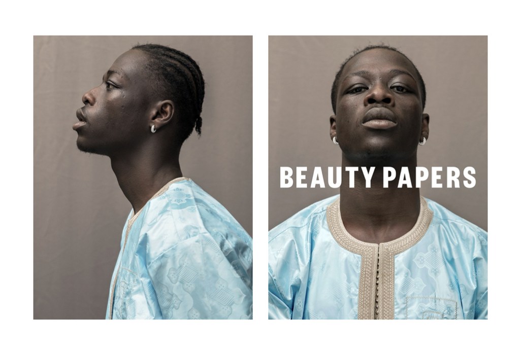 Portrait of an African male with light blue patterned clothing. The image features a split composition and the text BEAUTY PAPERS.