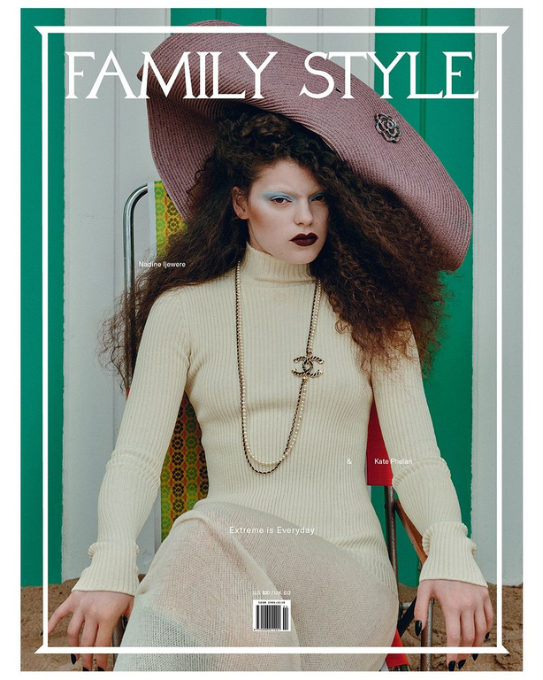 Magazine cover featuring a stylish woman wearing a tan turtleneck dress and an oversized hat, against a green and white striped background.