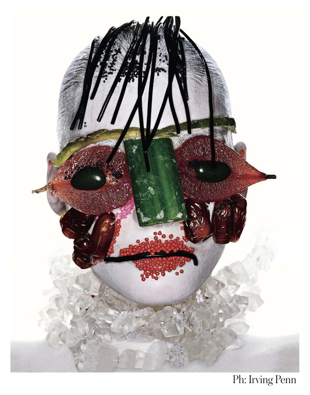 Surreal food portrait of a face made of fruits, vegetables, and crystal jewelry, set against a clean white background with Irving Penn's signature.