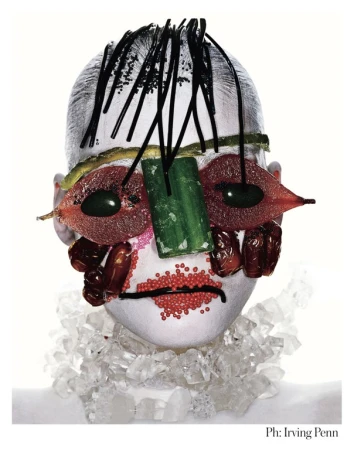 Surreal food portrait of a face made of fruits, vegetables, and crystal jewelry, set against a clean white background with Irving Penn's signature.